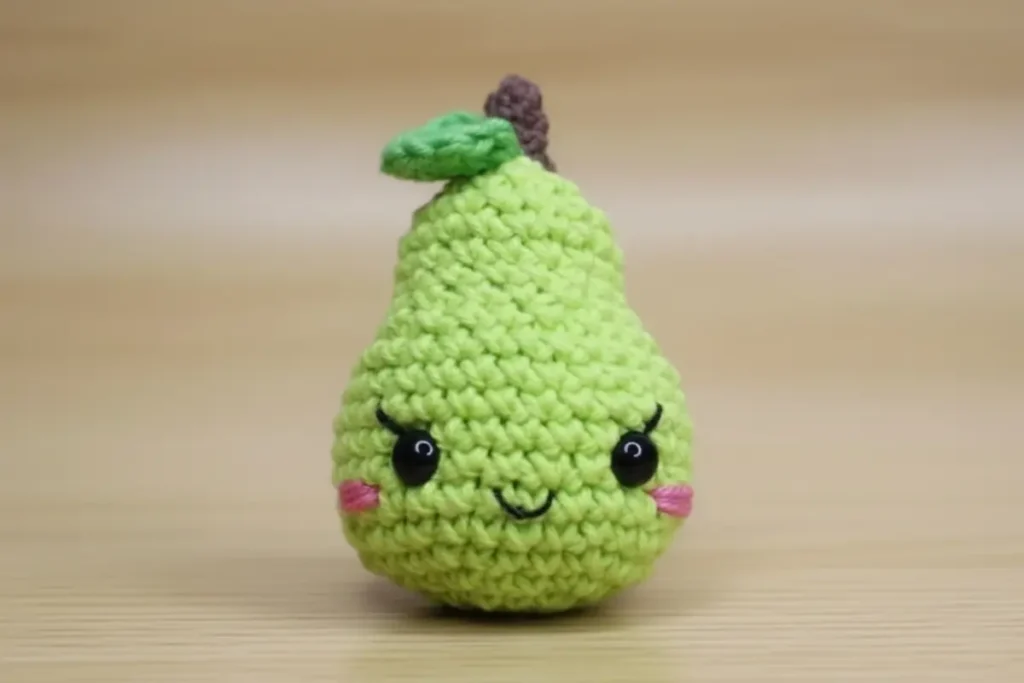 Cute pear amigurumi keychain with embroidered cheeks and leaf