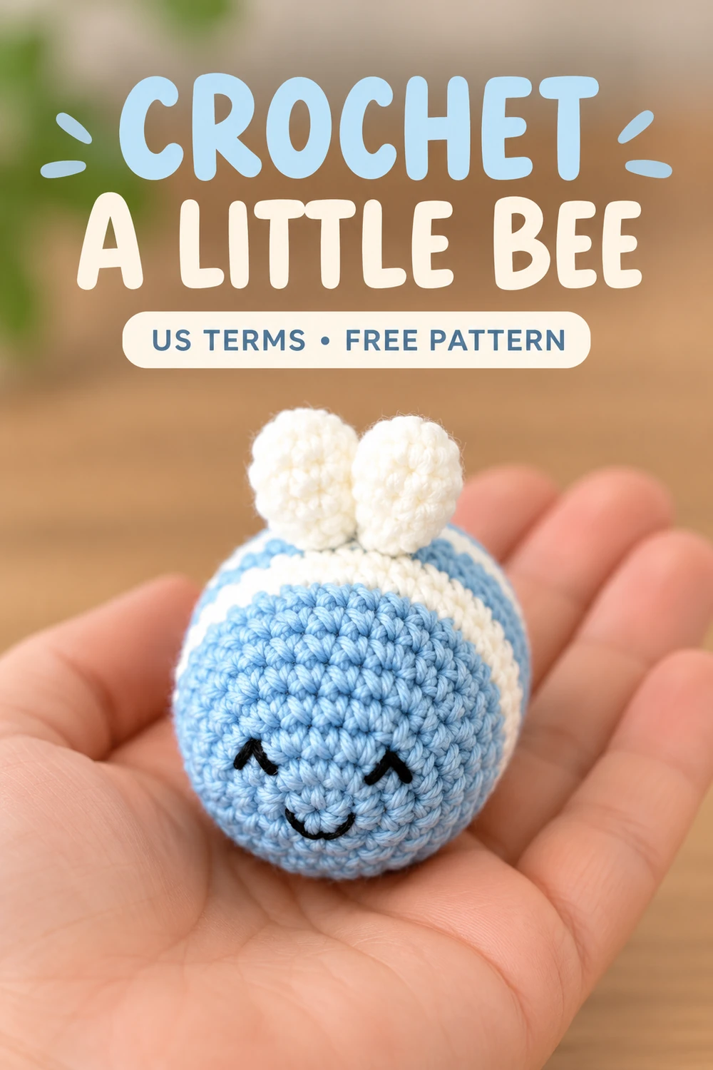 Small blue and white crochet bee resting in a hand