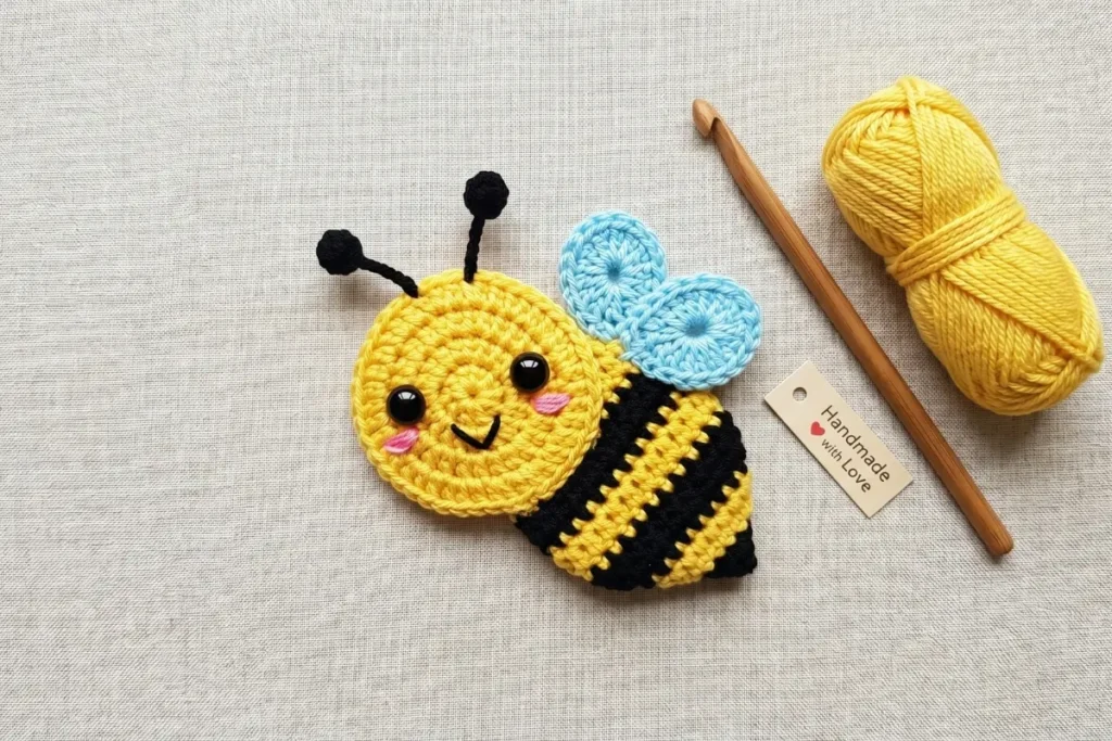 Cute Flat Bee Appliqué Crochet Pattern made with yellow and black yarn featuring kawaii wings and blush cheeks