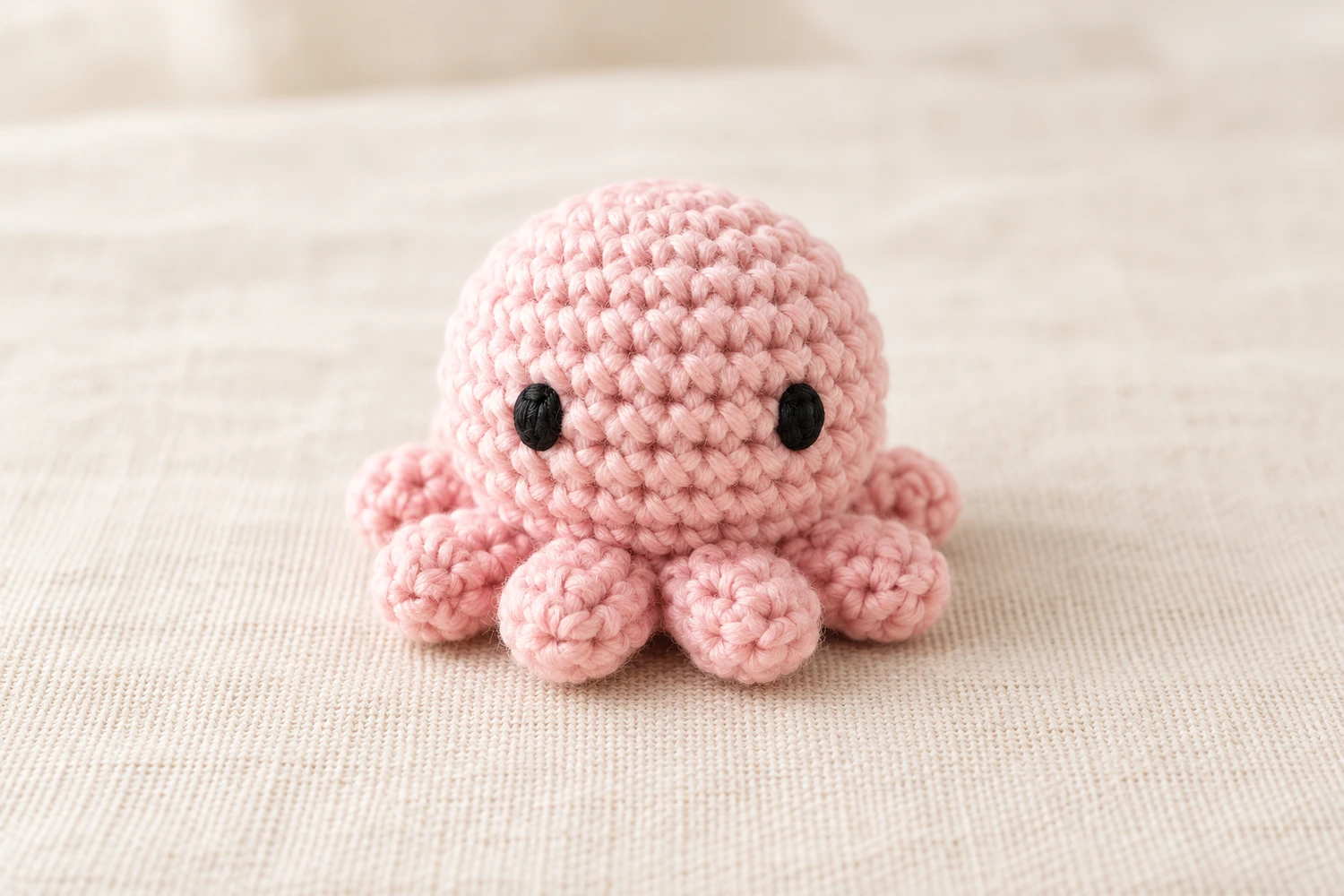 mini octopus crochet pattern with pink body and eight short curly arms