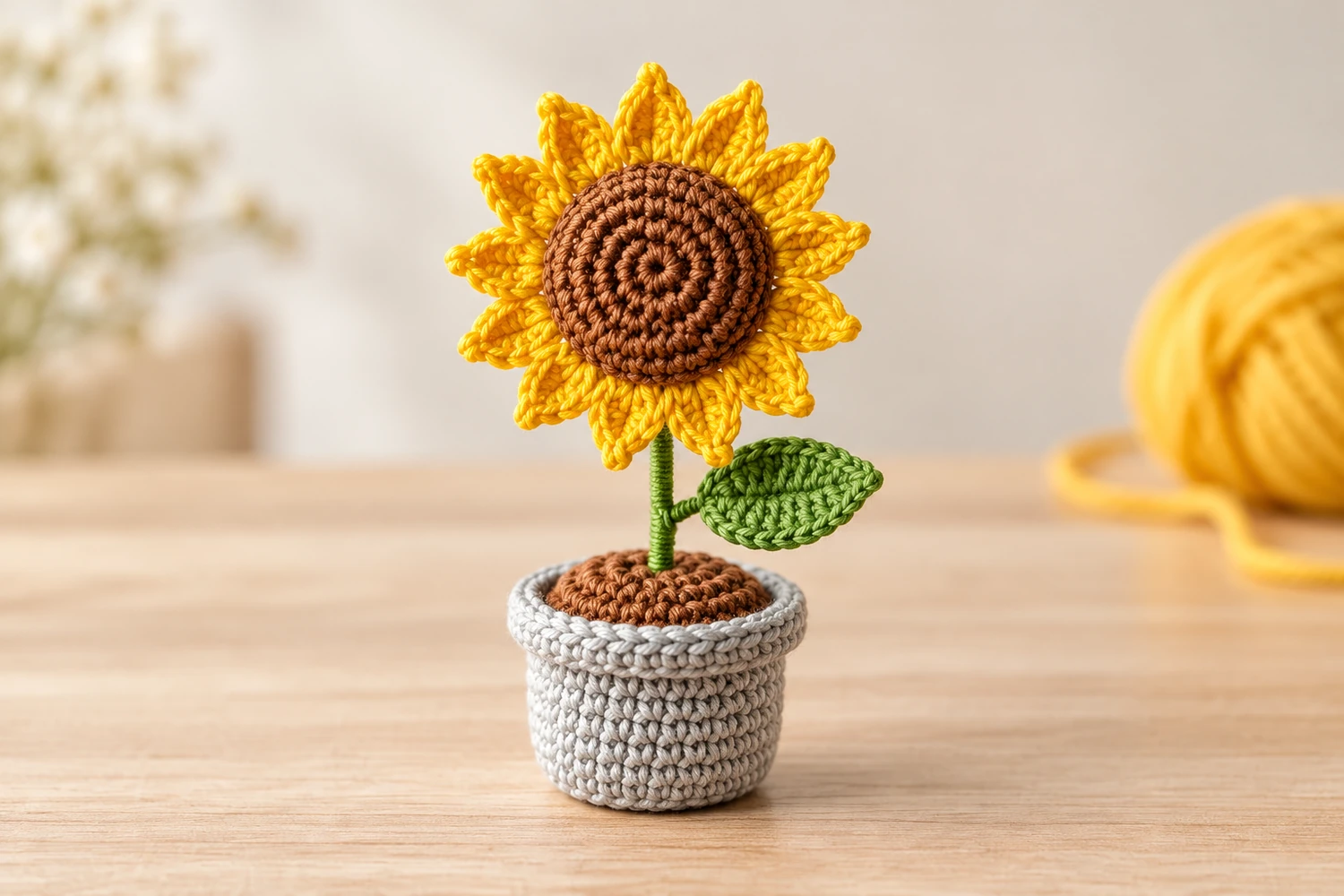 sunflower pot amigurumi with yellow petals, a green leaf and a gray pot